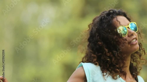 Cute biracial woman having great time, dancing to song and singing along to it photo