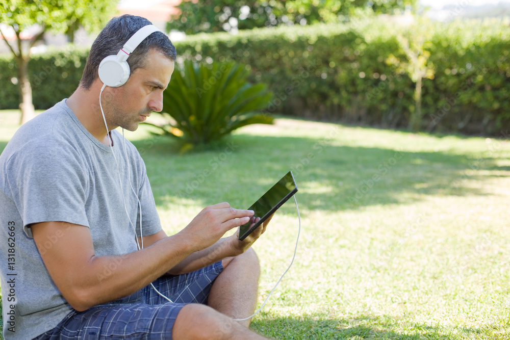 Obraz premium man relaxing with tablet pc