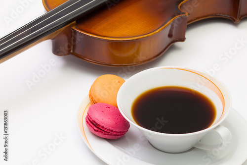 Old violin, cup of coffee and traditional french colorful macaro photo