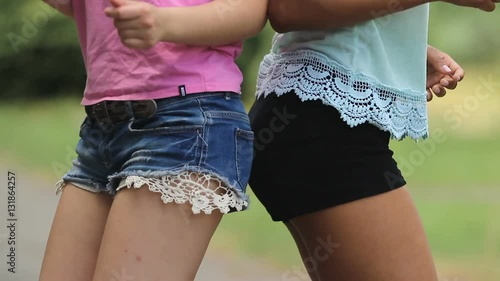 Two young ladies in short shorts making dances moves with their hips touching