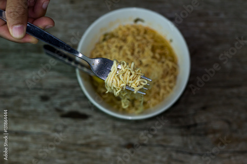Instant noodles in wooden bowl on wood background