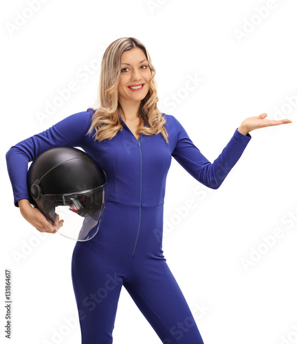 Female car racer holding helmet and gesturing with her hand