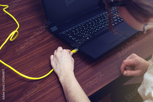 woman connect Internet cable to connector on the laptop