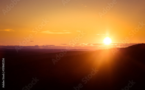 A beautiful landscape with a midnight sun above arctic circle. Dreamy scenery with light flares © dachux21