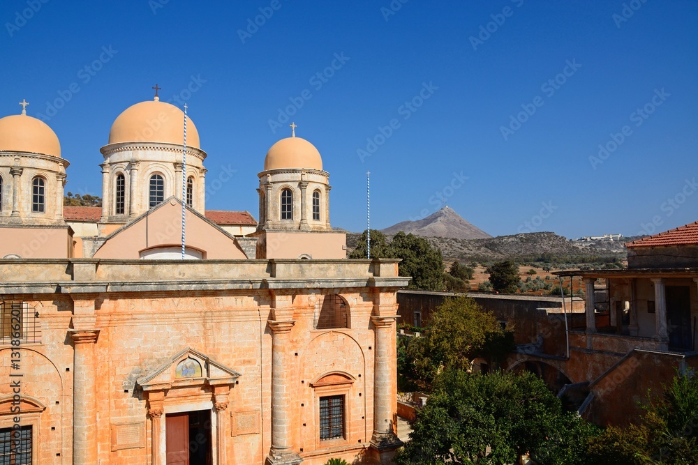 Elevated view of the front of the Agia Triada monastery with courtyard buildings to the left, Crete.