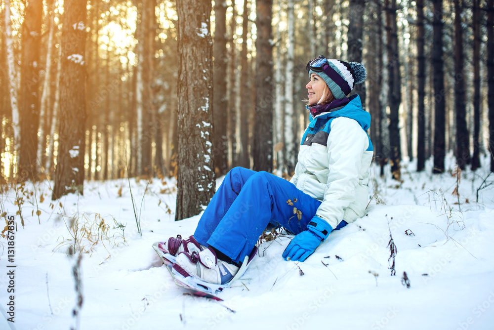woman snowboarder with snowboard is resting sitting on the snow