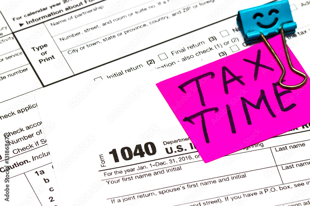 Tax time written on a bright sticker note paper clip for a tax Tax time written on a bright sticker note paper clip for a tax
