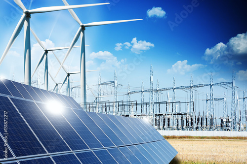 Modern electric grid lines and renewable energy concept with photovoltaic panels and wind turbines photo
