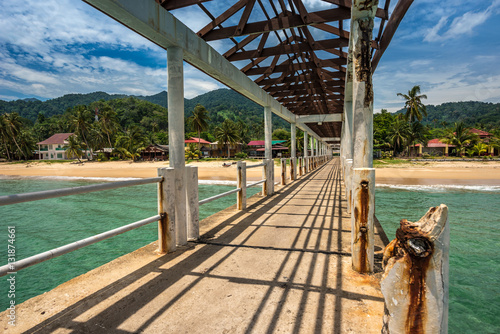 Old pier with some rust on a deserted beach on a sunny day, Tioman, Malaysia photo