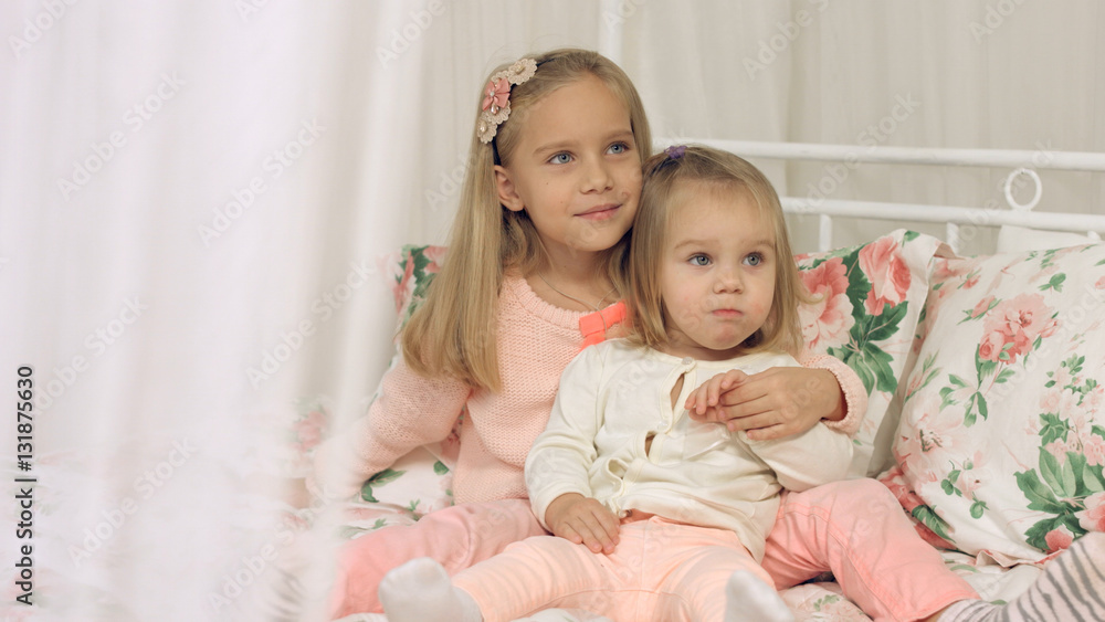 Two little sisters sitting on the couch Two little sisters sitting on the couch