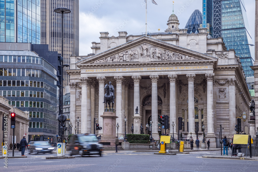 Fototapeta premium London, England - The Royal Exchange building with moving traditional black london taxi