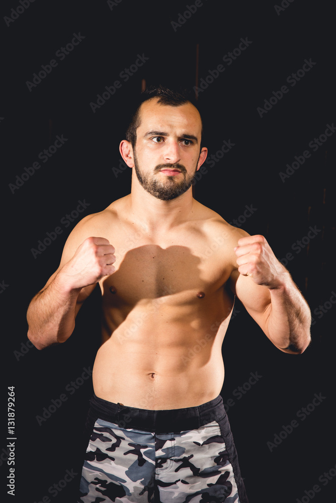 Athlete standing in a boxing guard isolated with a dark background