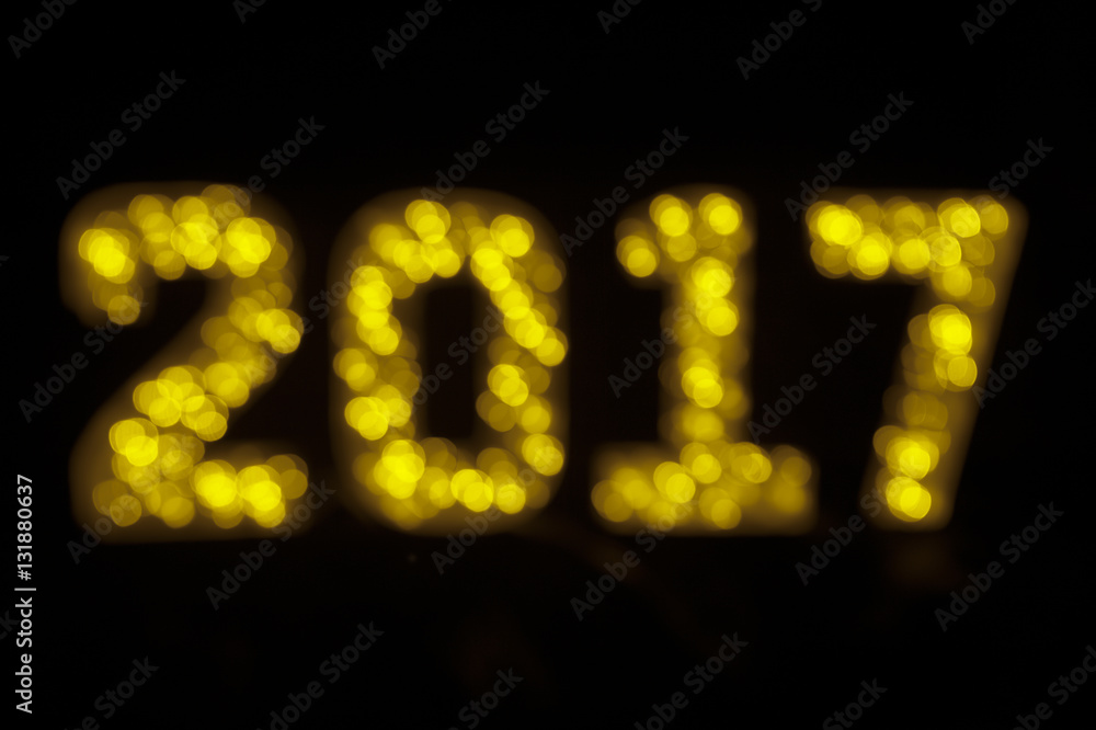 Happy New Year 2017 message in glowing bokeh lights on black background