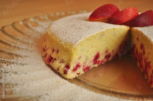 Fruit sponge cake on a serving plate decorated with fresh fruit