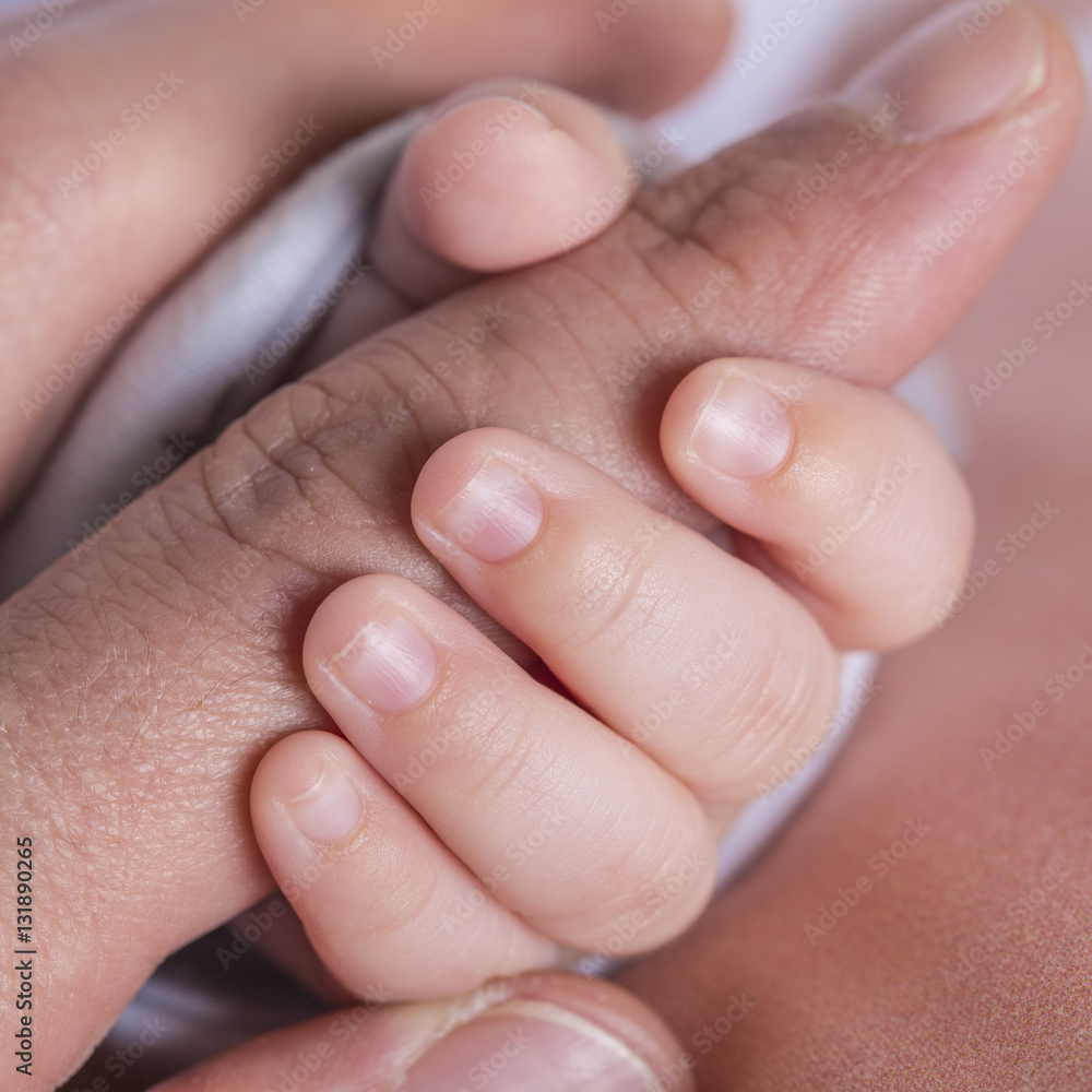 Baby hand holding father's finger Baby hand holding father's finger