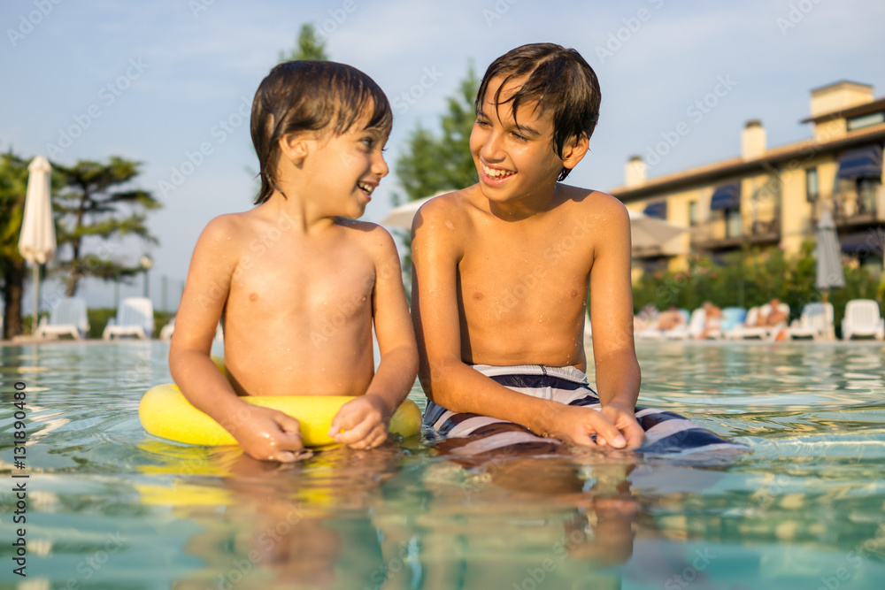 Young boy kid child splashing in swimming pool having fun leisur Young boy kid child splashing in swimming pool having fun leisur
