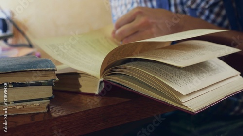 man reading an old education book close-up turns the page video