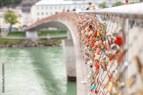 The view to Makartsteg bridge over Salzach River, Austria's most modern pedestrian bridge in Salzburg, that attracts a lot of tourists and lovers that hand the padlocks. photo