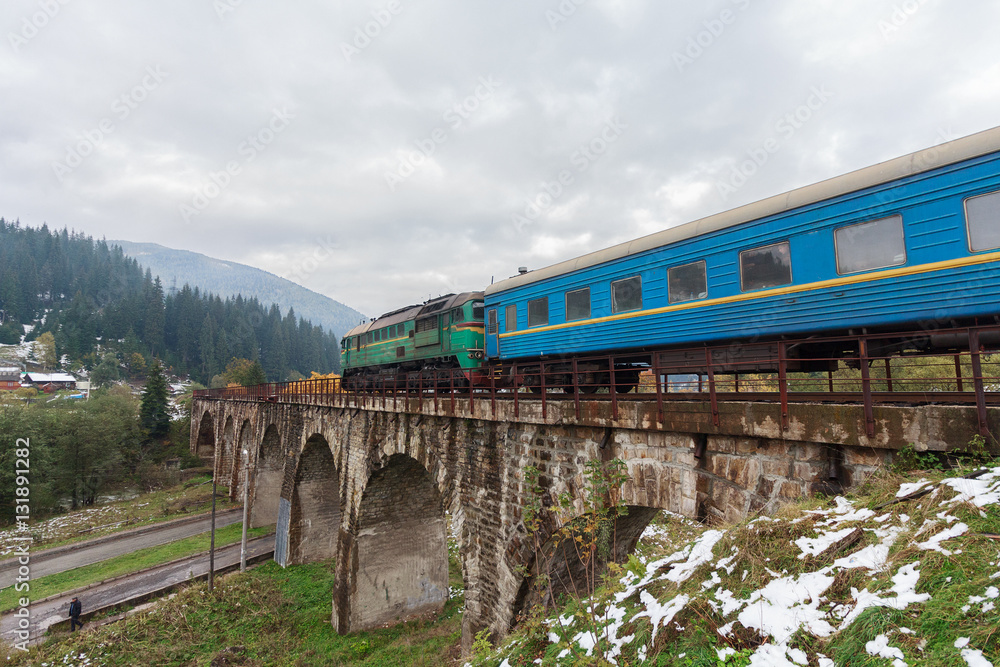 Diesel train traveling on the viaduct. Vorokhta, Ukraine Diesel train traveling on the viaduct. Vorokhta, Ukraine