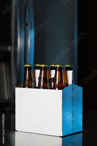Fotografie Six pack of brown beer bottles on kitchen counter