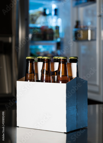 Obraz na plátně Six pack of brown beer bottles on kitchen counter