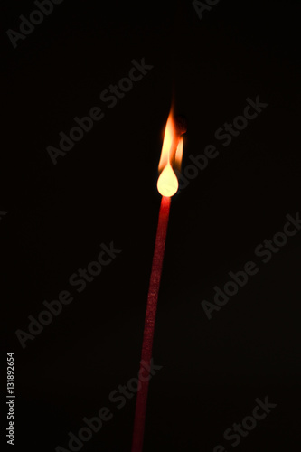 Burning matchstick on black backround.
