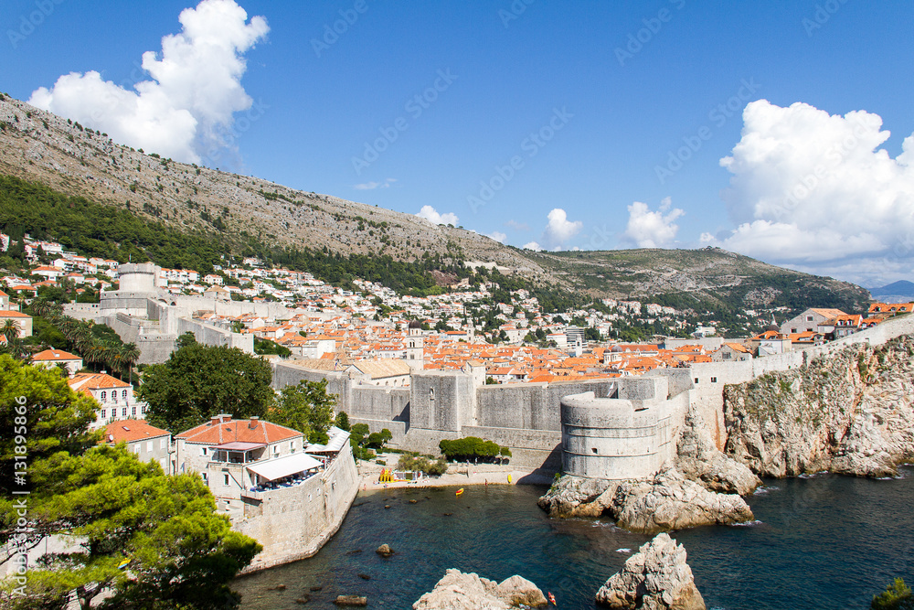 Old city of Dubrovnik in Croatia surrounded by the medieval wall, with the sea and a blue sky