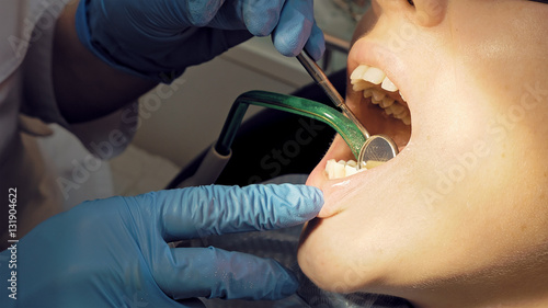 Woman at the dentist clinic office gets dental medical examination and treatment. Close up shot. Odontic and mouth health is important part of modern human life that dentistry help with.