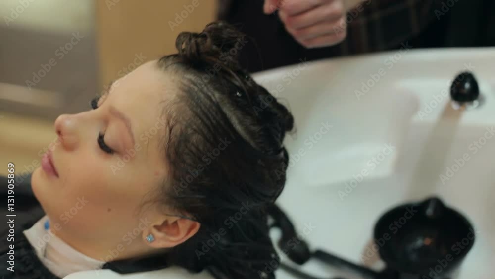 The Barber makes a hair mask with oil for a girl with long hair. The Barber makes a hair mask with oil for a girl with long hair.