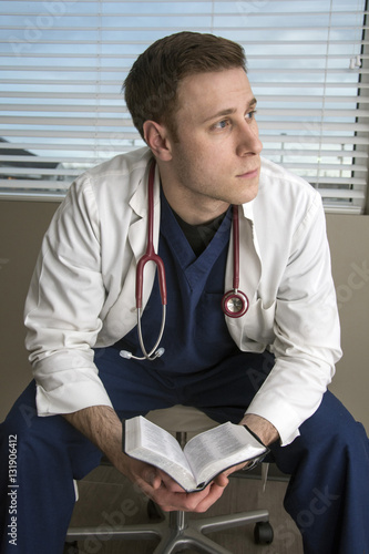 doctor reading his bible in between helping his patients