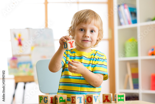 Cuadro en lienzo Little preschooler kid boy playing with toy cubes and memorizing letters