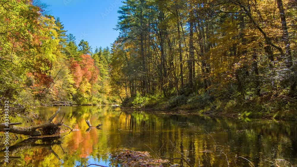 Vibrant Autumn Colors on the Linville River with Water Movement on a Sunny Day with a Blue Sky at Linville Falls in the Blue Ridge Mountains of North Carolina Vibrant Autumn Colors on the Linville River with Water Movement on a Sunny Day with a Blue Sky at Linville Falls in the Blue Ridge Mountains of North Carolina
