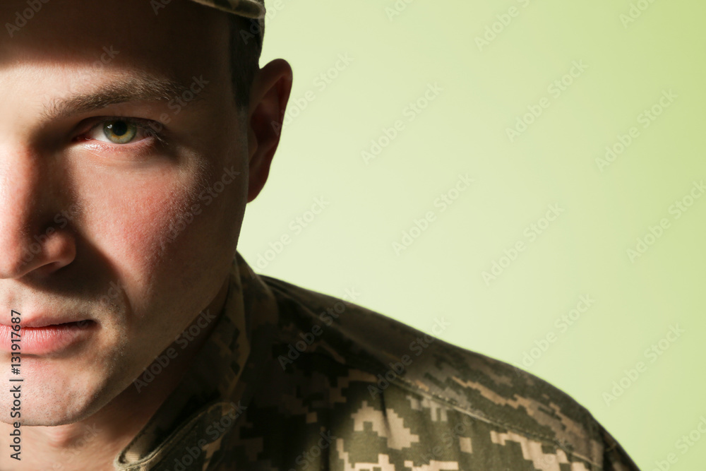 Soldier in camouflage on grey background, closeup Soldier in camouflage on grey background, closeup