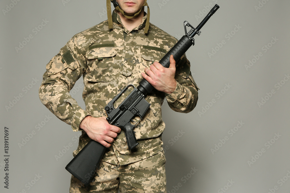 Soldier with assault riffle on grey background Soldier with assault riffle on grey background