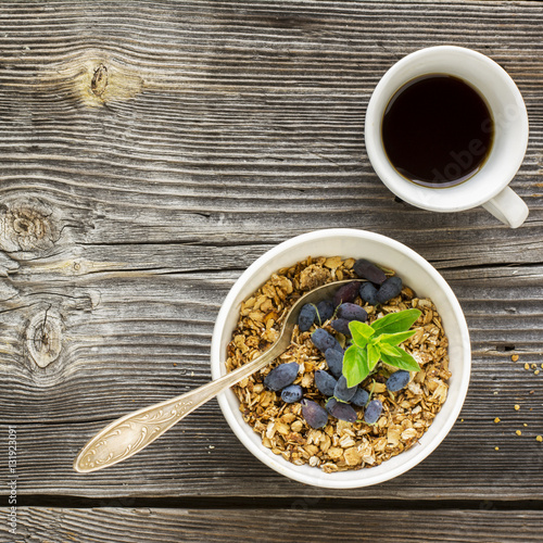 Fototapeta Naklejka Na Ścianę i Meble -  Healthy breakfast. Honey crisp flavorful granola with nuts and berries  fresh floral  on wooden gray background. selective focus
