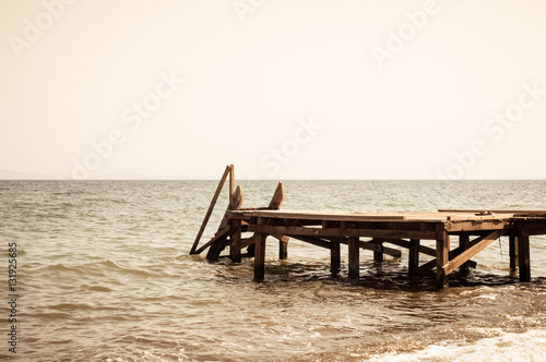 View of a wooden pier and seascape with running waves