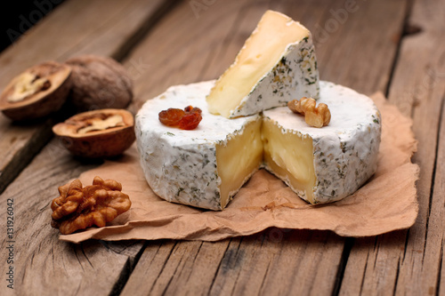 Camembert with nuts,raisins and on rustic wooden background.selective focus