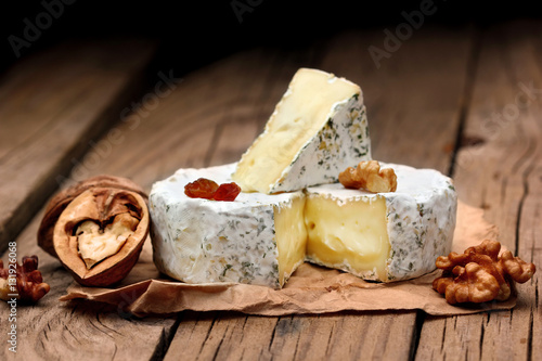 Creamy Camembert with nuts,raisins and on rustic wooden background.selective focus