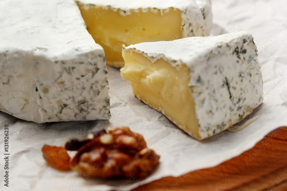 Camembert and brie cheese on wooden background with nuts spices . closeup .selective focus