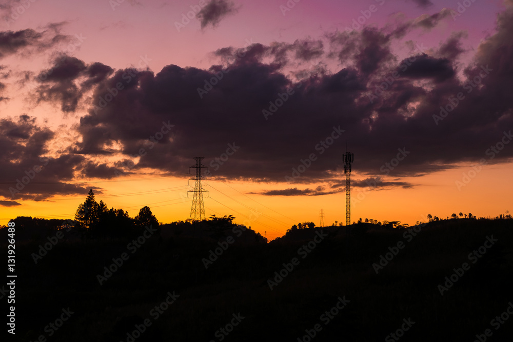 silhouette of high voltage and telephone pole on mountain during sunset sky with cloud