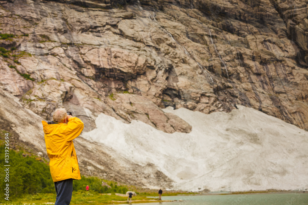 Tourist taking photo in norwegian mountains