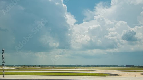 Wide Side View of the Airfield with a Commercial Passenger Airliner Taking Off into Ominous Clouds at Atlanta International Airport photo