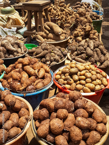 Different root vegetables and potatoes for sale from buckets on local market in Cameroon, Africa