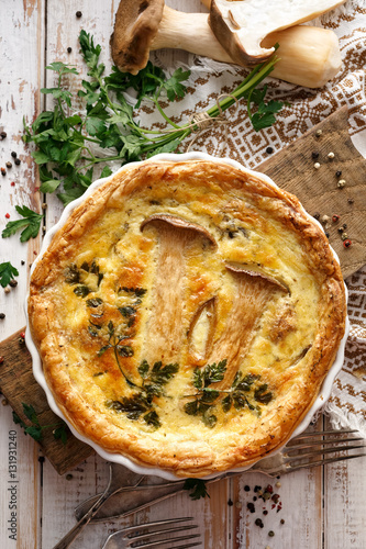 Mushroom quiche on a wooden table, top view