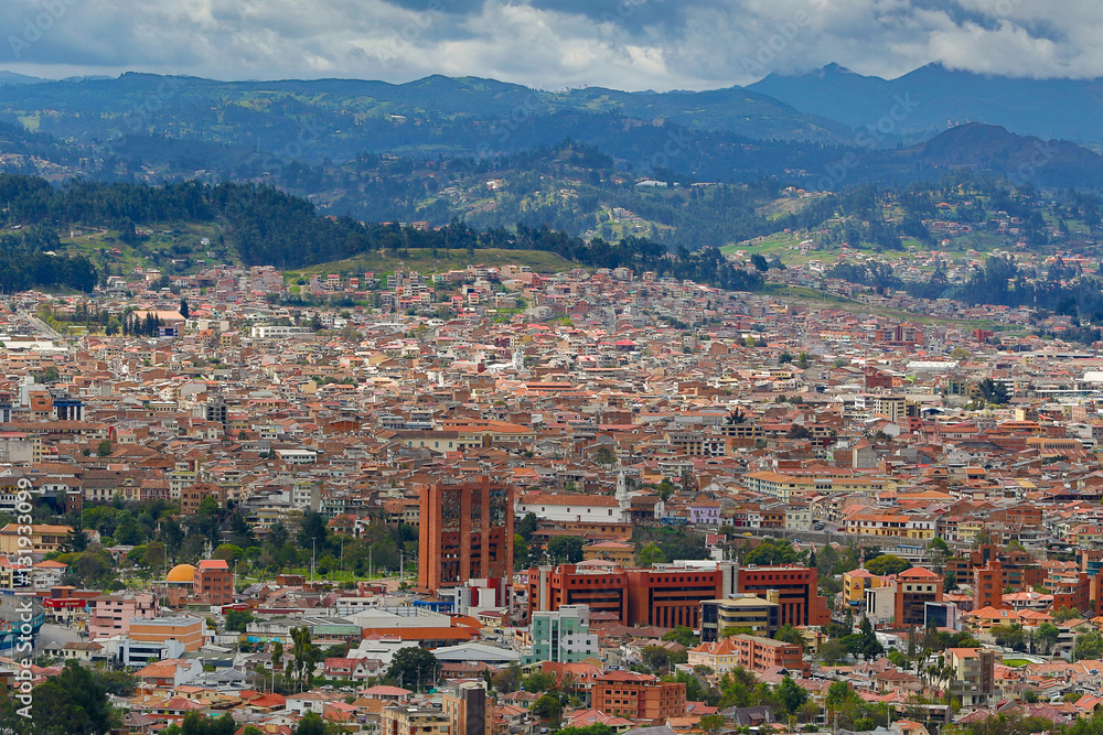the city of Cuenca Ecuador seen from above with mountains in the background and cloudy sky