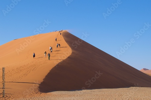 Namib-Naukluft National Park, Namibia - August 2016: Visitors walking up Dunes 45