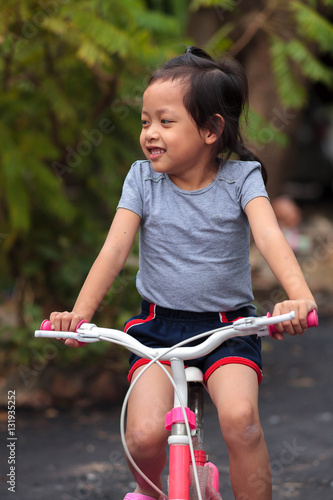 Smiling asia child on a bicycle, Selective focus.