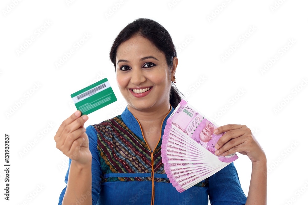 Cheerful Indian woman holding a bunch of Indian rupee notes and a credit card Cheerful Indian woman holding a bunch of Indian rupee notes and a credit card