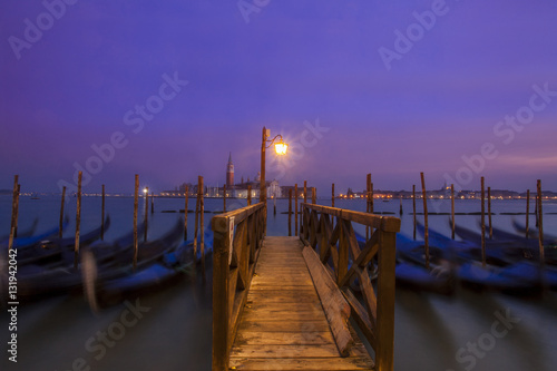 Long exposure of gondolas at twilight in Venice, Italy. In the background is the island of San Giorgio Maggiore.