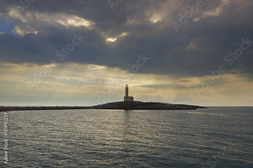 Apulia coast:Vieste Lighthouse dominated by clouds.It' is located on the islet of Santa Eufemia opposite the town of Vieste.Italy.Its location is strategic for the shipping lanes in the Sea Adriatic.